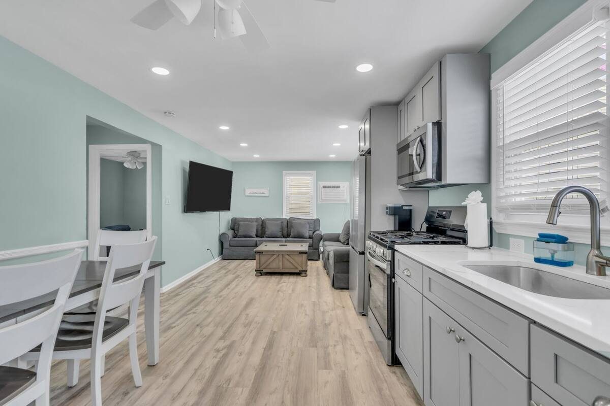 Paxley's open kitchen and living room with seaglass walls and grey shaker cabinets